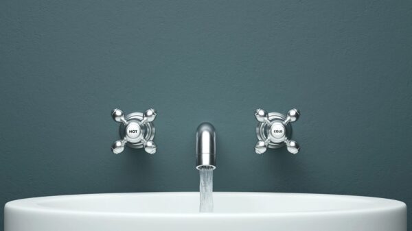 an open faucet attached to a blue wall
