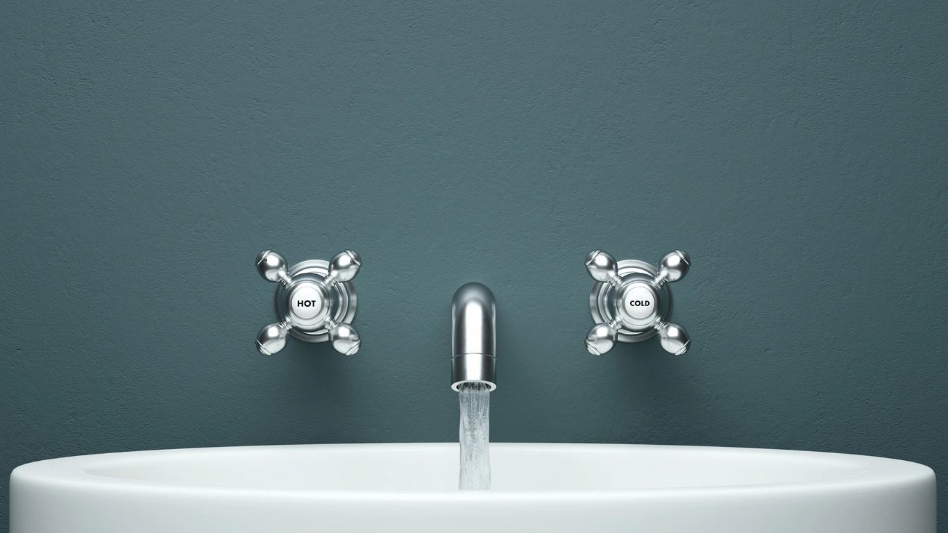 an open faucet attached to a blue wall